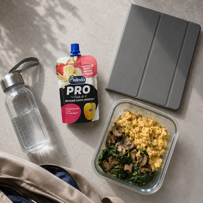 Snack proteico PRO Melinda banana e fragola ambientato con la frutta